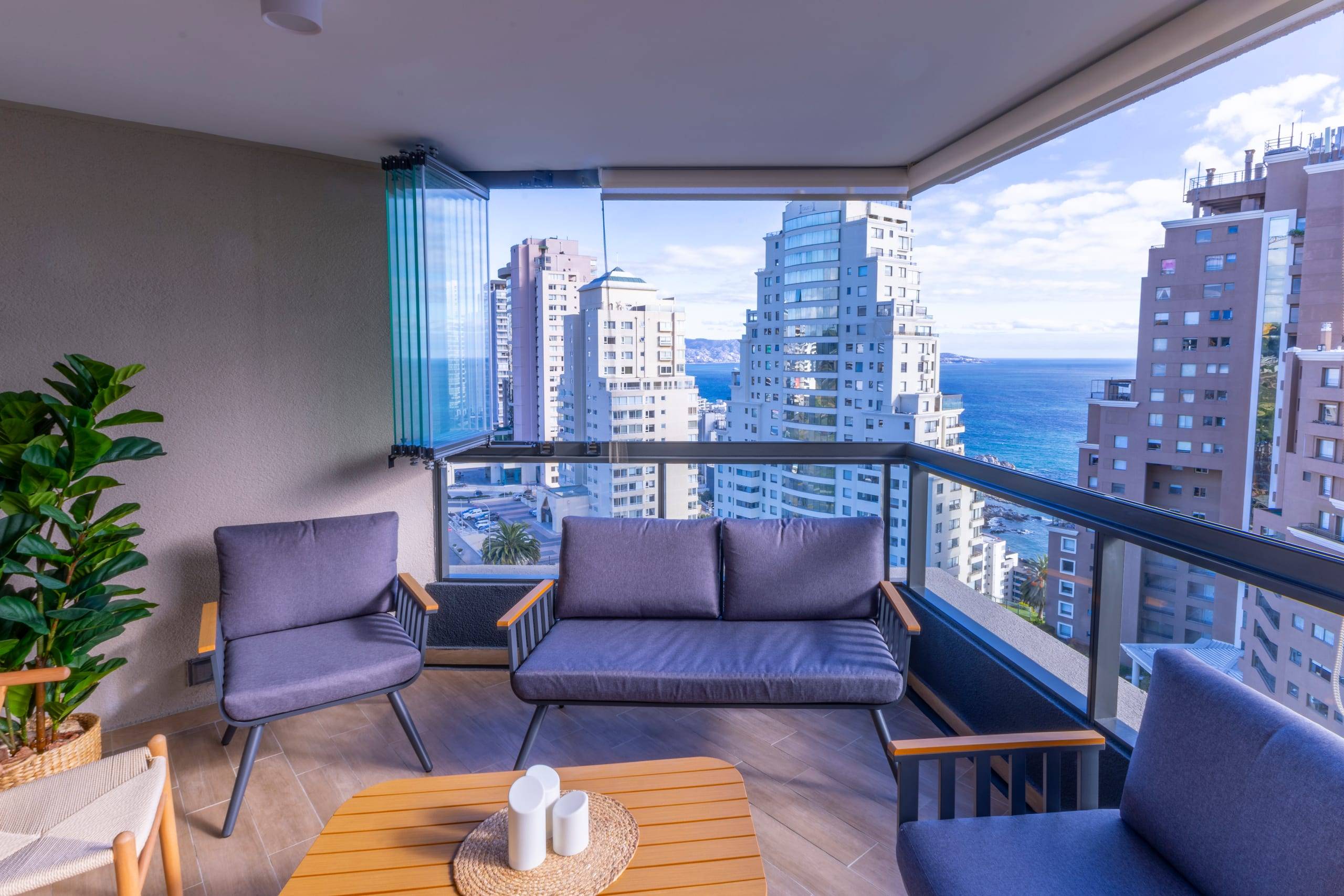 Balcón con sofá y vista al mar y a la ciudad, departamento en Concón