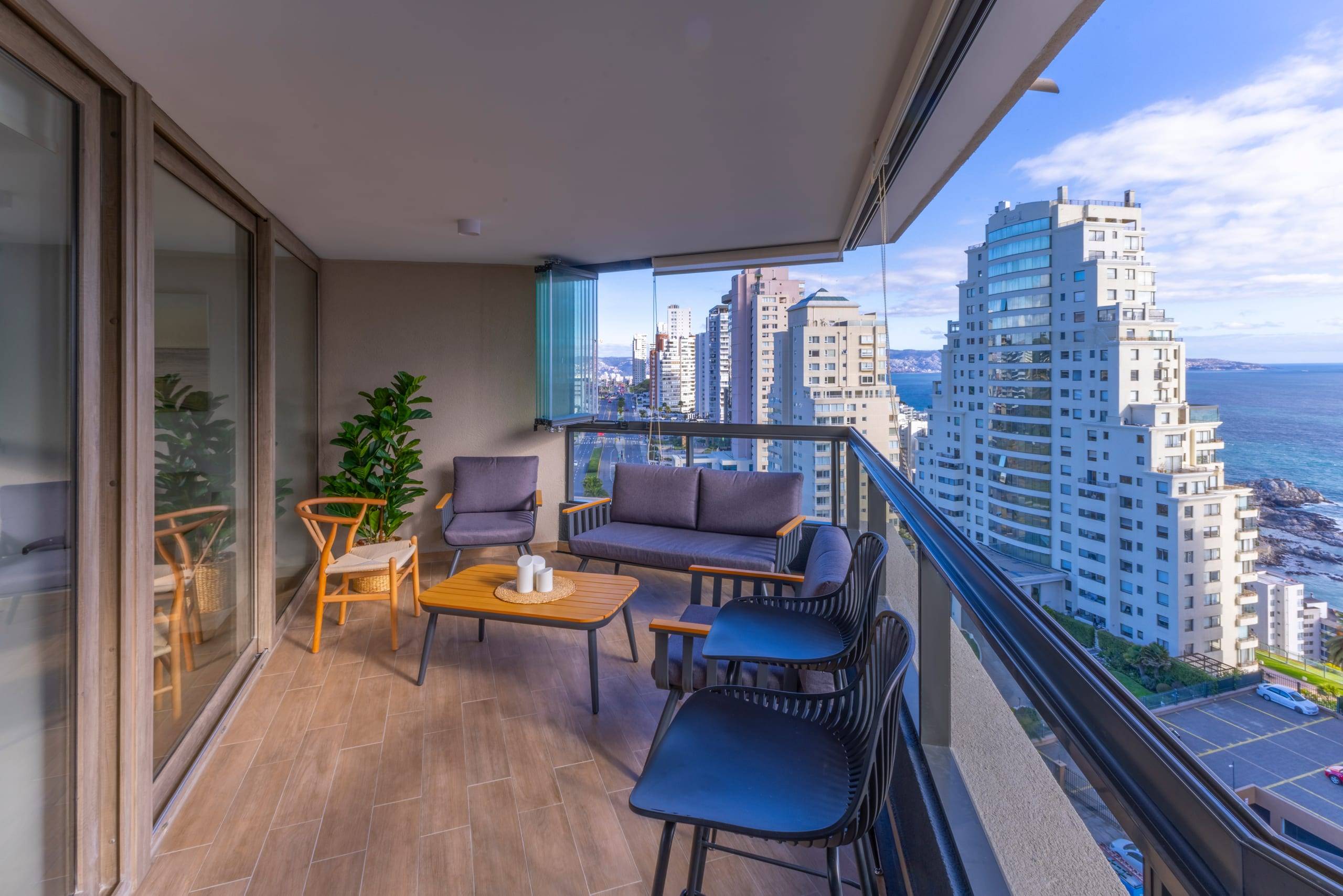 Terraza con sillones y vista a la costa desde departamento en Concón