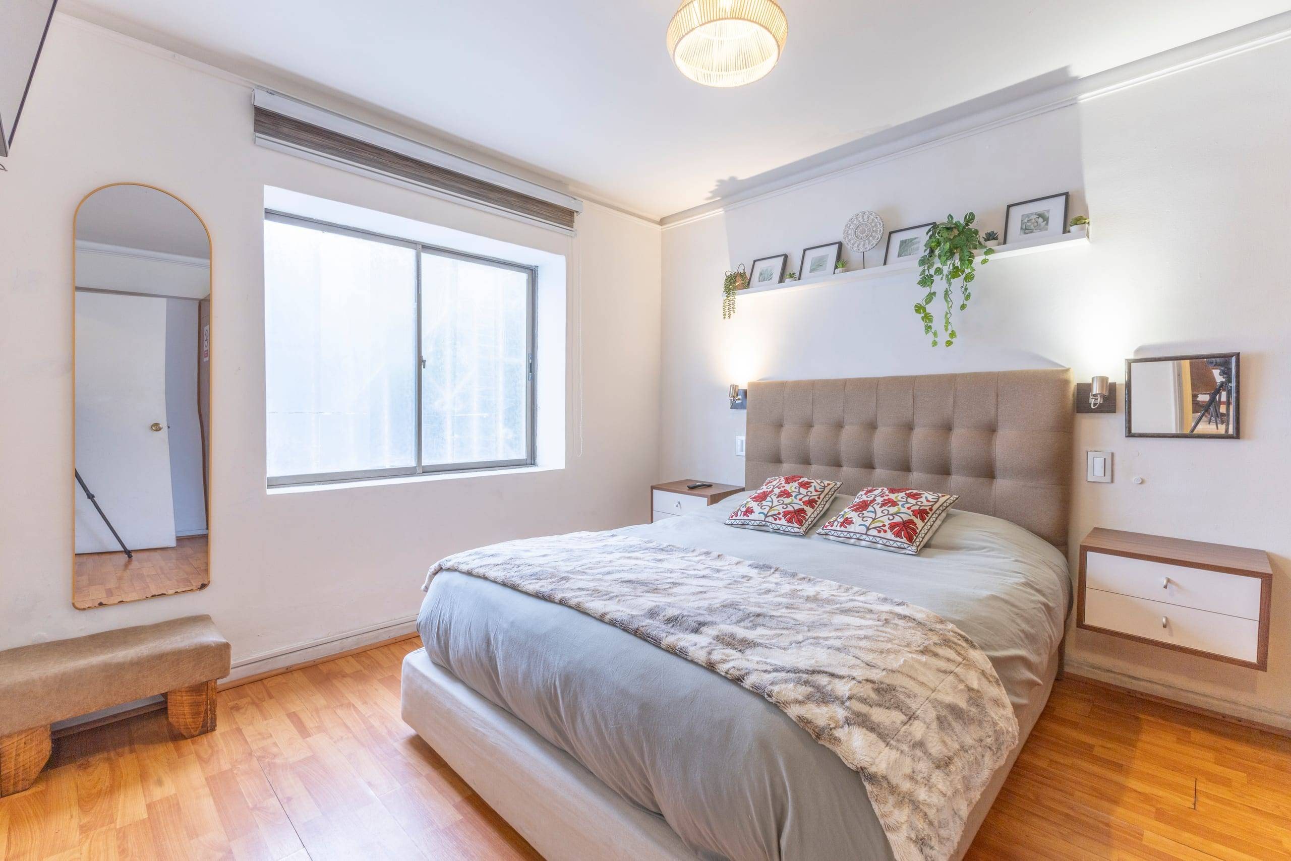 Dormitorio principal con respaldo tapizado y buena iluminación