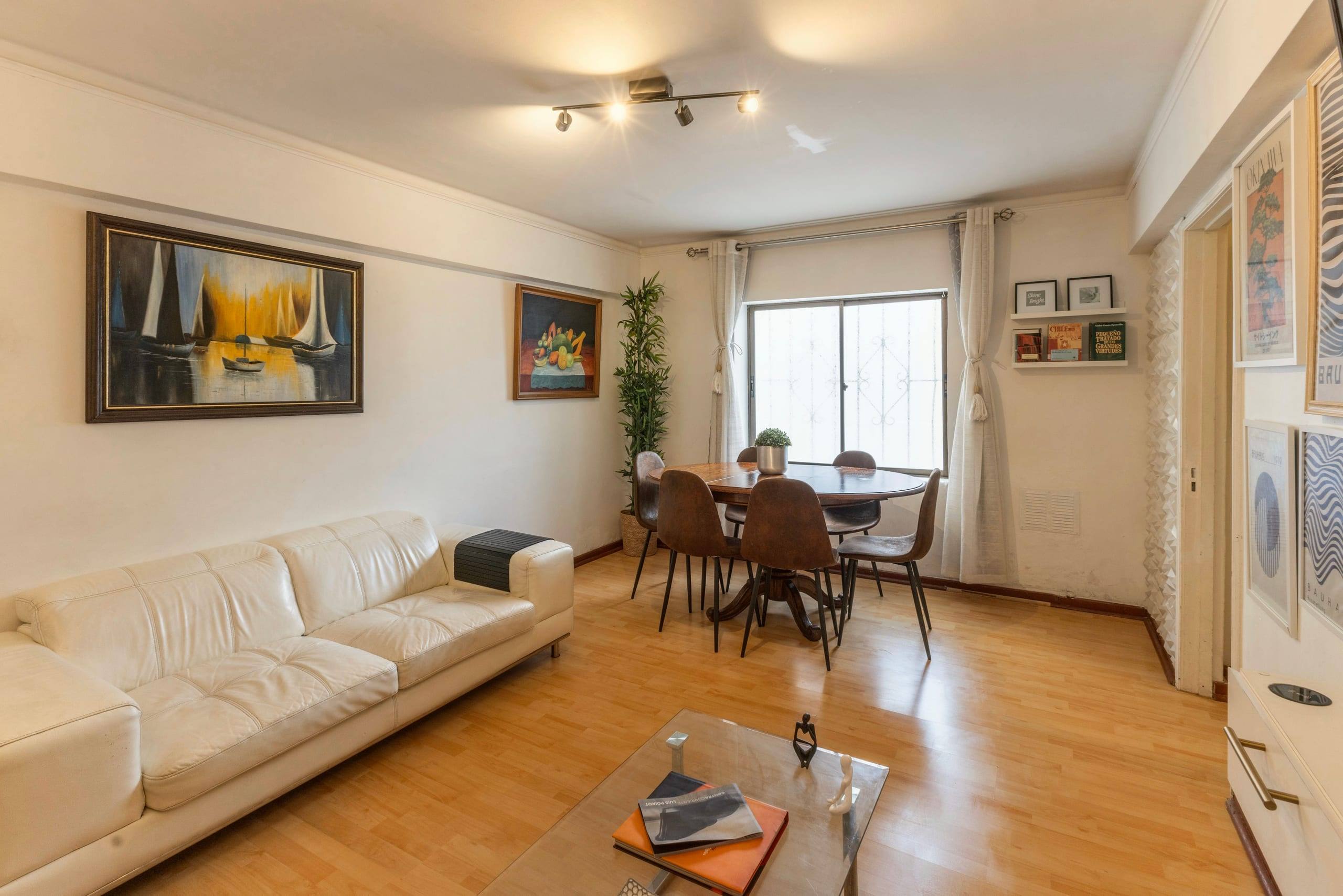 Living luminoso con sofá blanco y chimenea, fotografía inmobiliaria profesional en Viña del Mar