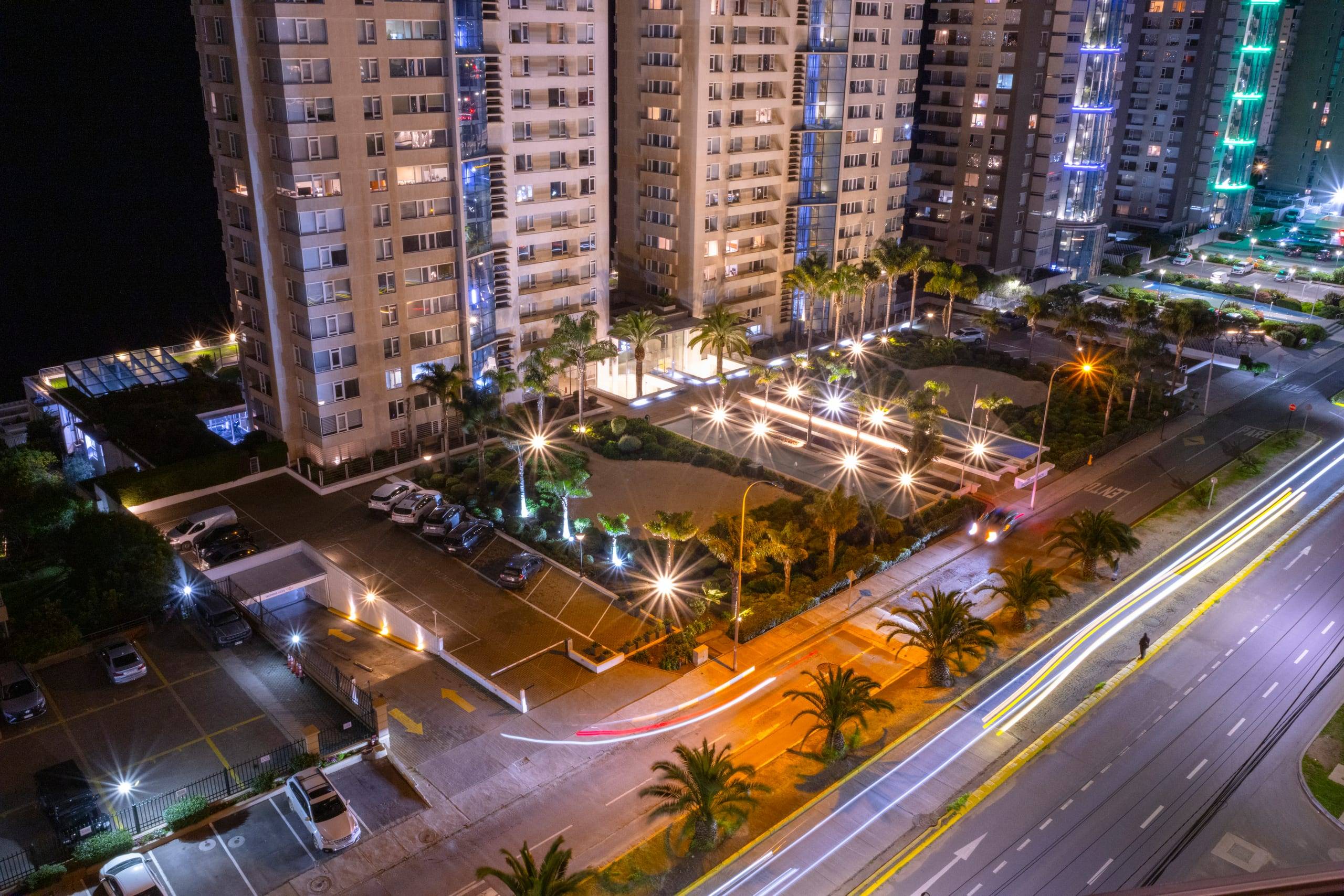 Vista nocturna de la avenida iluminada y el borde costero