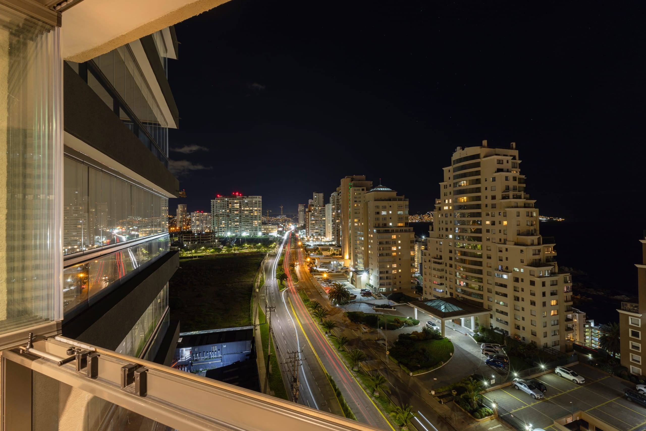 Vista nocturna de la costa y las luces de la ciudad desde el balcón